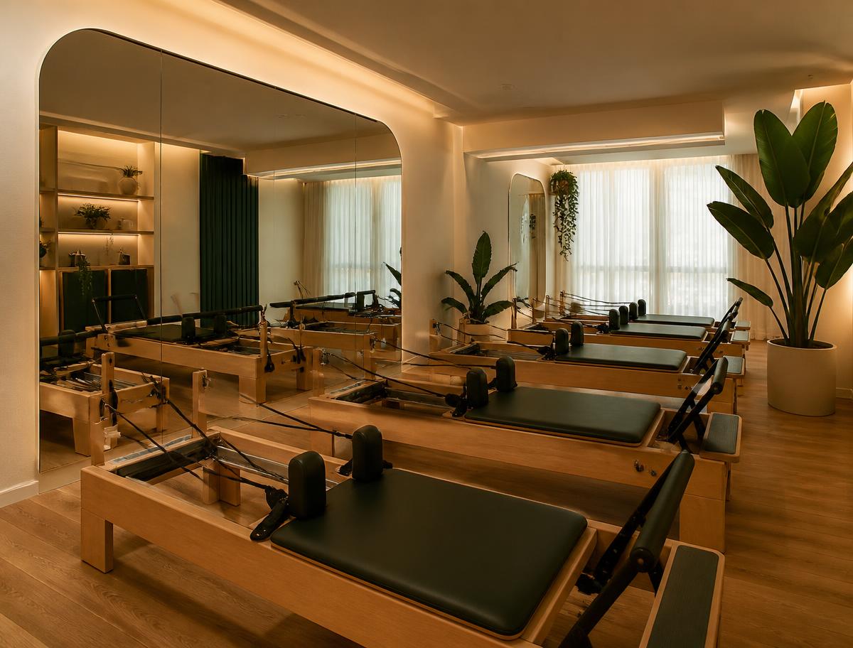 Sala do estúdio com aparelhos de Pilates e iluminação suave